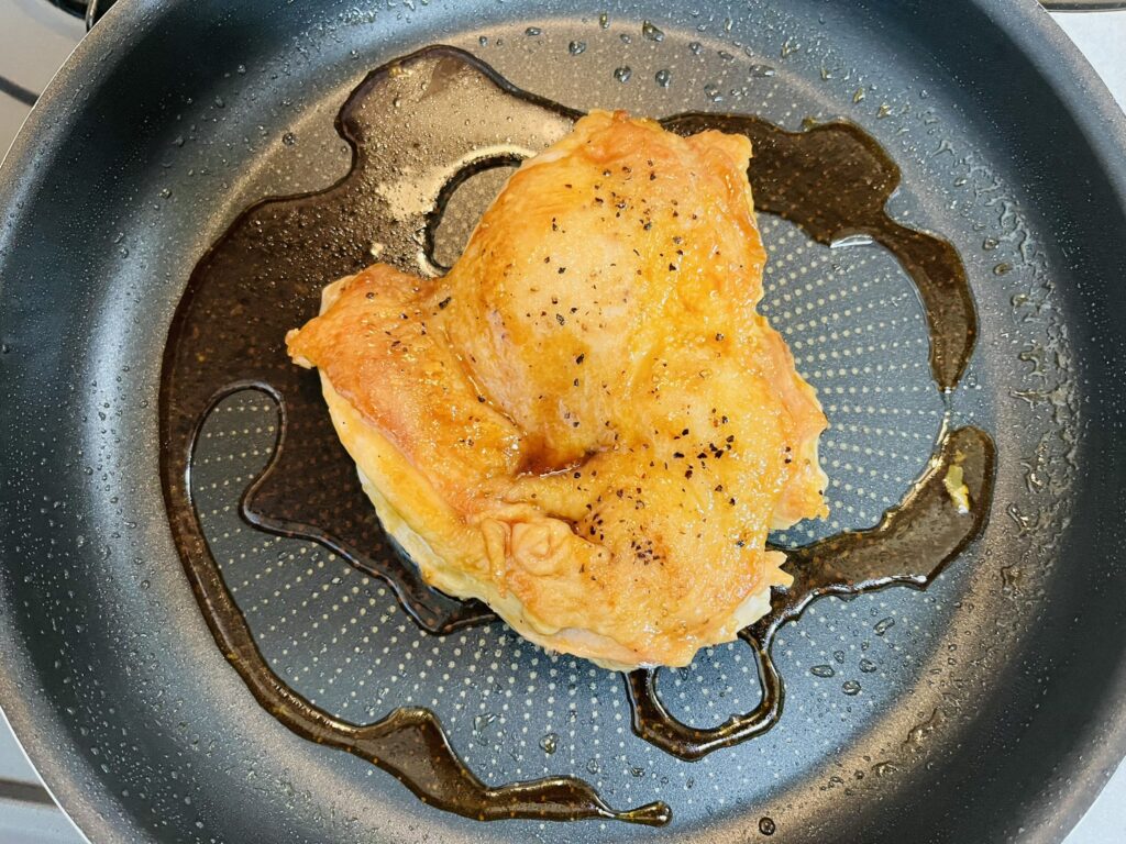 焼けたコストコさくらどりもも肉にすき焼きのタレをかけて絡め焼きをする