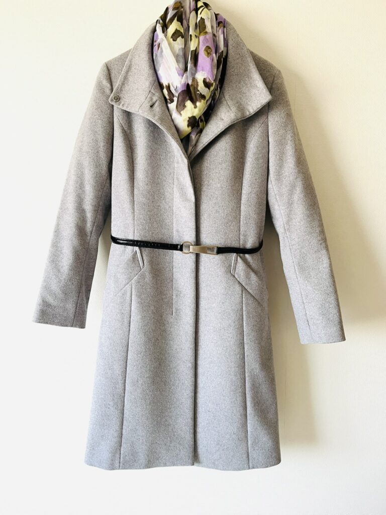 ライトグレーのウールコートの40代向けコーデ。春らしい色のストールを合わせた。毛玉やよごれは目立ちにくいので、寿命が長い。お手入れも簡単。