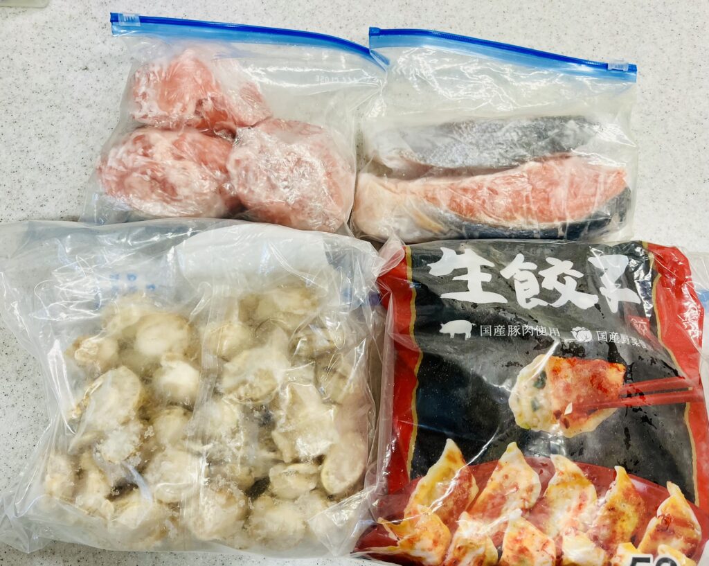 鍋のメイン具材はコストコの人気商品。豚ロース、銀鮭、ベビーホタテ、冷凍餃子。どれも安価で節約になる。