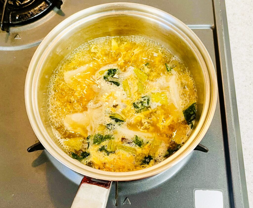 鍋で冷凍水餃子を市販スープで煮込んでいる
