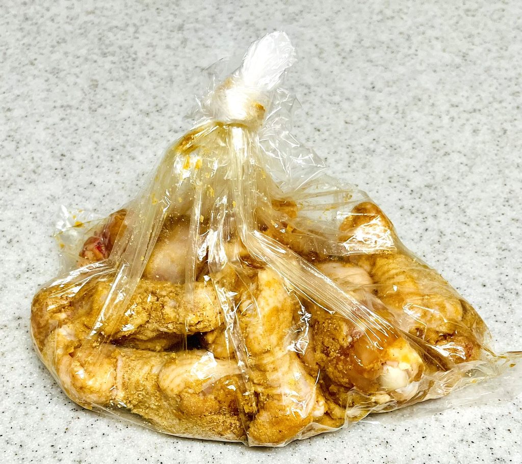 コストコさくらどり手羽元にフライドチキン用の下味をつける作業。ポリ袋に材料を全て入れている。