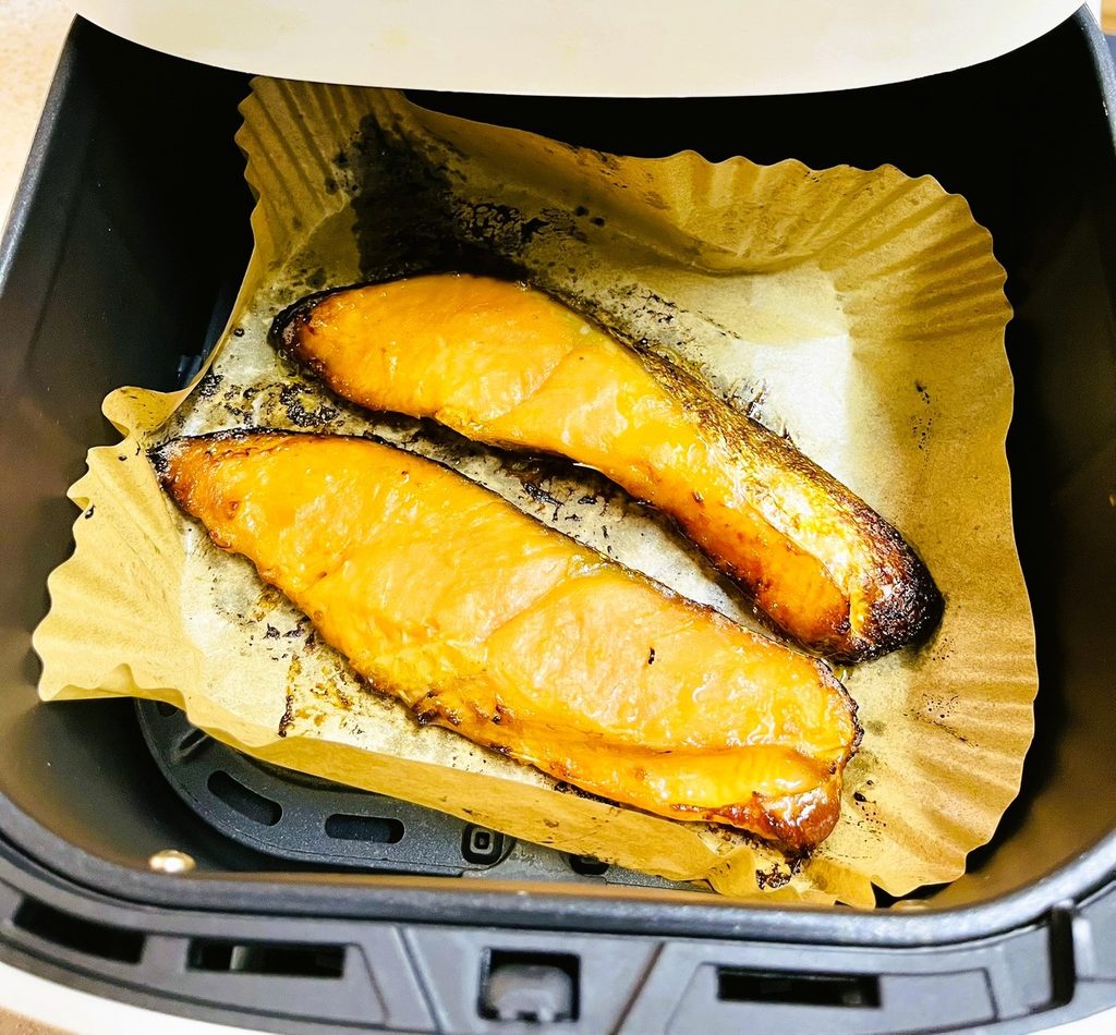 凍った状態の鮭西京焼きの切り身をノンフライヤーで焼いた。均一な焦げ目。専用シート使用でバスケットが汚れない。時短家事