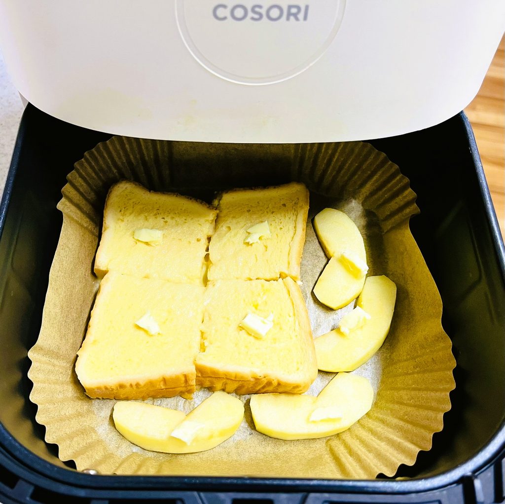 卵液を染み込ませたパンと林檎をノンフライヤーにセットし、上からバターを少しずつのせた