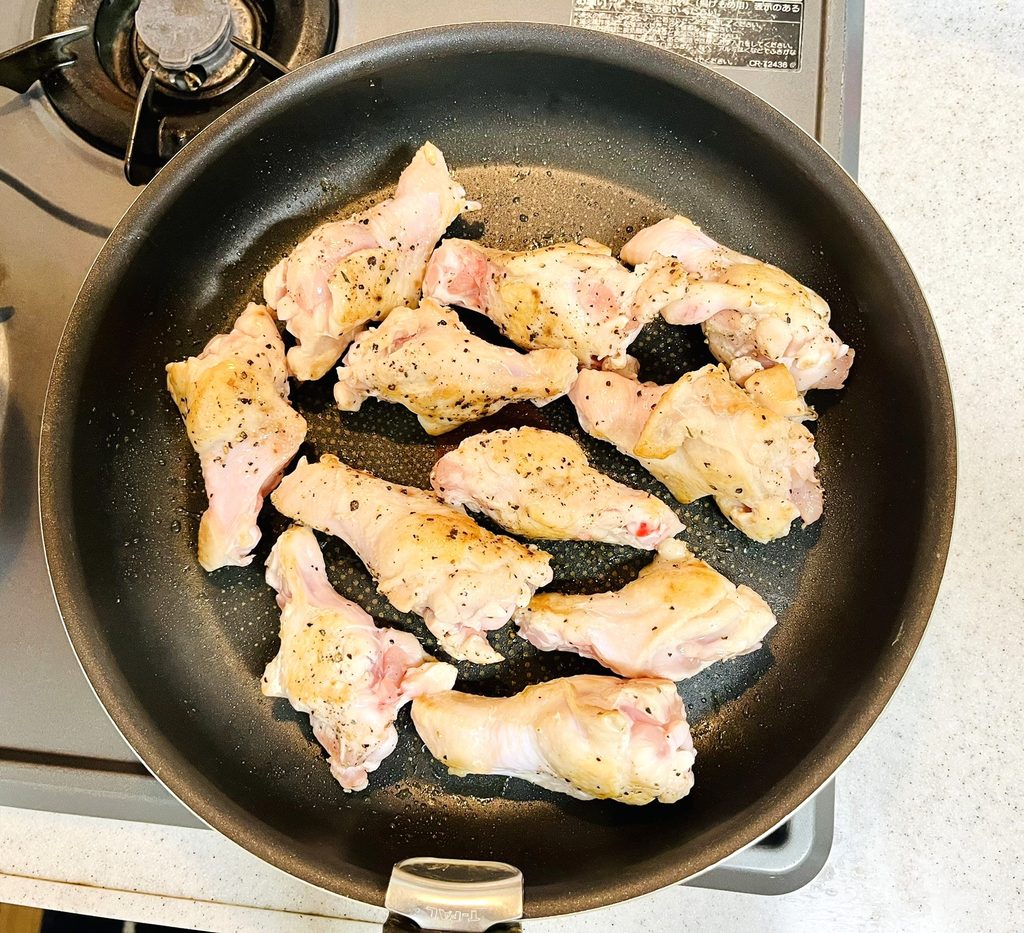 塩コショウで下味を付けたコストコさくらどり手羽元をフライパンで焼き色を付けている。